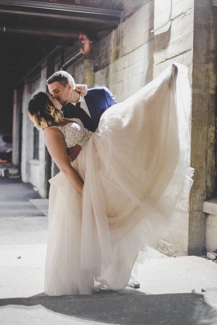 Fantastic Finds couple, Andria and Travis, posing and kissing on their wedding day